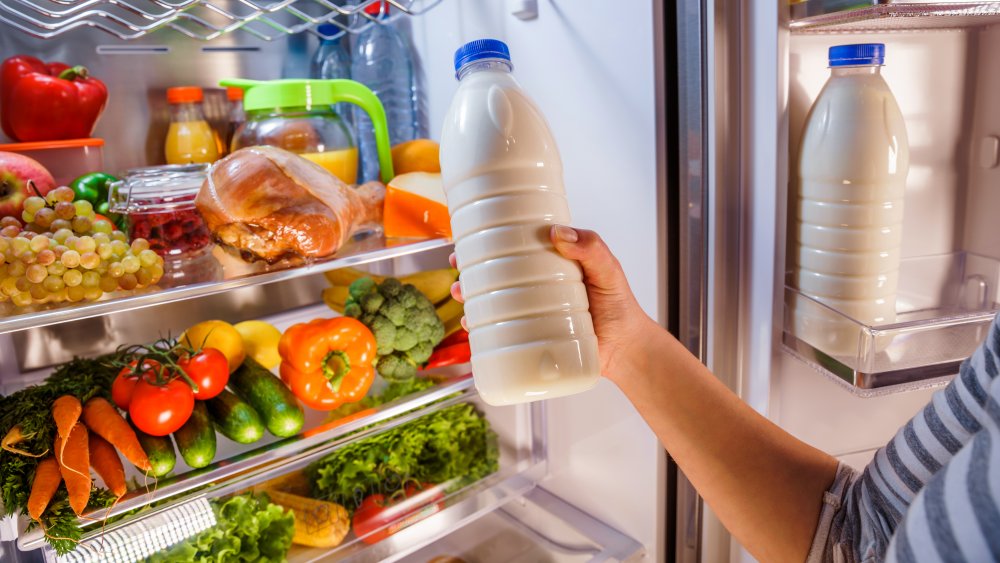 Person taking bottle of milk out of refrigerator