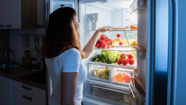 woman looking in refrigerator