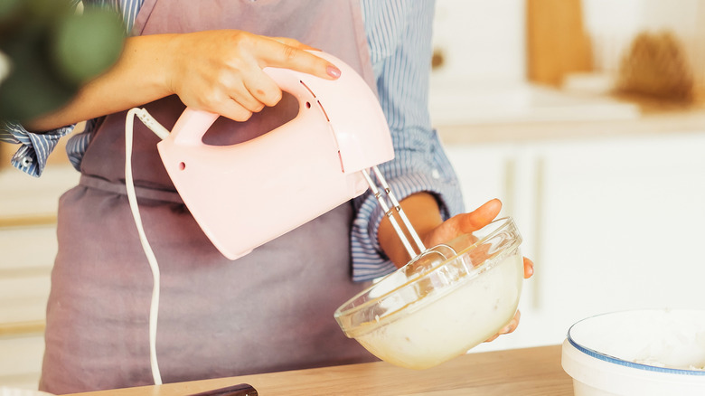 Person using hand mixer 