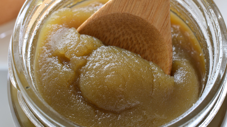 Coconut jam in jar with wooden spoon